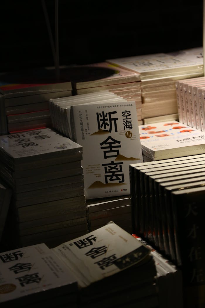 A collection of stacked books in a dimly lit bookstore setting with prominent Chinese text.